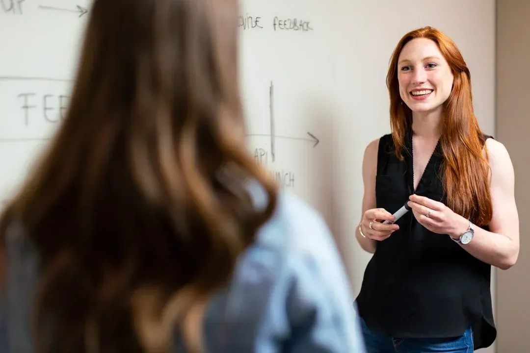 Woman teaching marketing strategy using a whiteboard